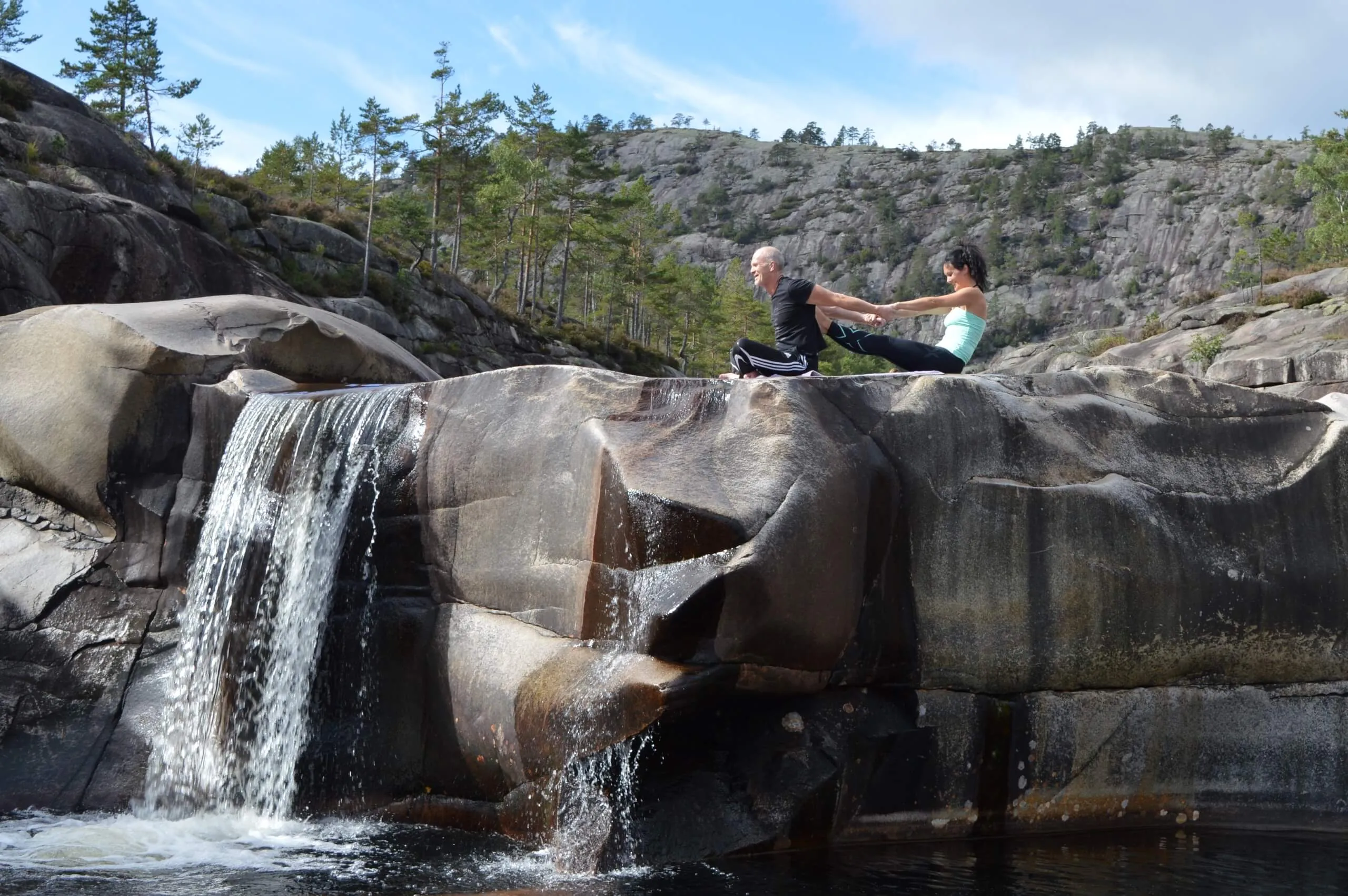 Thaimassasje og strekking på en fjellhylle ved en foss i Nissedal